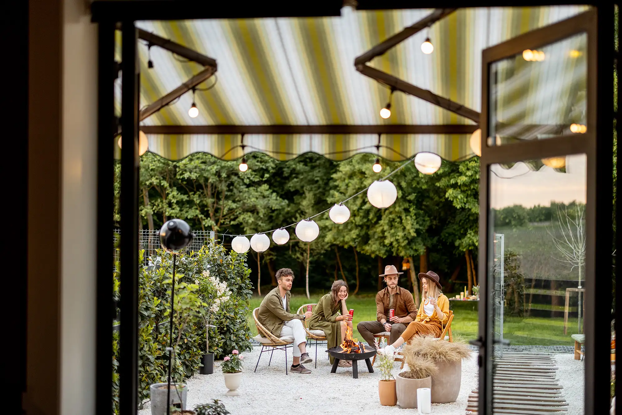 Reunión de amigos en terraza con jardín con toldo Reunión de amigos en terraza con jardín con toldo